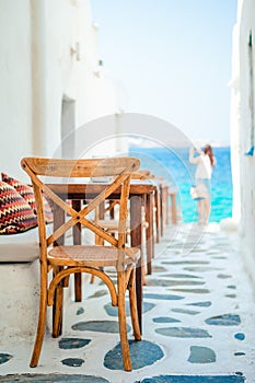 Benches with pillows in a typical greek outdoor cafe in Mykonos with amazing sea view on Cyclades islands