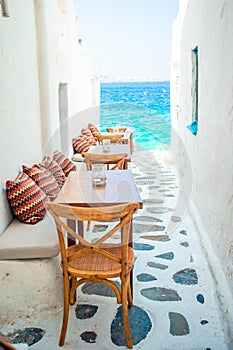 Benches with pillows in a typical greek outdoor cafe in Mykonos with amazing sea view on Cyclades islands