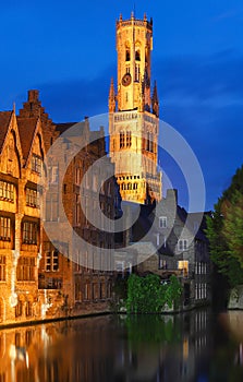 Famous view of Bruges tourist landmark attraction - Rozenhoedkaai canal with Belfry and old houses along canal with tree in the