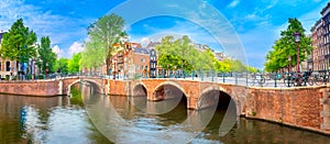 Famous view of  heart of Amsterdam. Beautiful day, blue sky, old sloping houses, bridges and canals. Panoramic Amsterdam