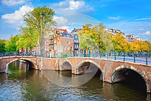 Famous view of the soul of Amsterdam. Beautiful day, blue sky, old sloping houses, bridges and canals