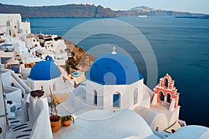 Famous view from viewpoint of Santorini Oia village with blue dome of greek orthodox Christian church