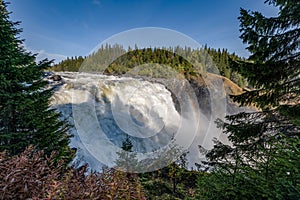 Famous waterfall Tannforsen northern Sweden, with a rainbow in the mist and rapid flowing cascades of water