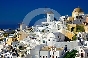 Famous windmills and cityscape of Oia town on Santorini island in Greece. Traditional white houses. Greece, Aegean Sea. Popular