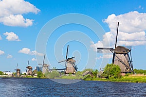 Famous windmills in Kinderdijk village in Holland. Colorful spring landscape in Netherlands, Europe. UNESCO World Heritage and fam