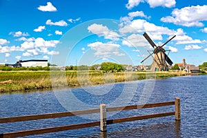 Famous windmills in Kinderdijk village in Netherlands. Colorful spring rural landscape with windmill and river. UNESCO World