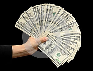 Fan of dollars in a female hand black background