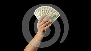 Fan of dollars in a male hand on a black background