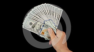 Fan of dollars in a male hand on a black background