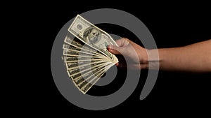 Fan of dollars in a male hand on a black background