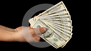 Fan of dollars in a male hand on a black background