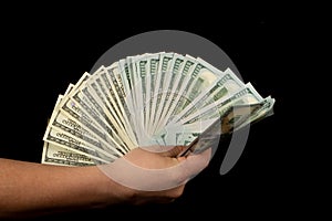 Fan of dollars in a male hand on a black background