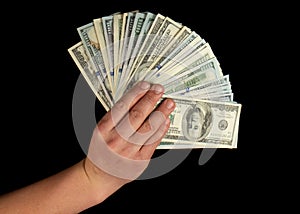 Fan of dollars in a male hand on a black background