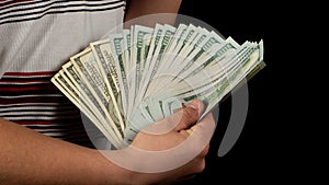 Fan of dollars in a male hand on a black background