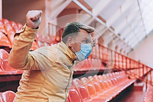 A fan in an empty sports stadium is rooting for the team. Concept on the theme of COVID-19