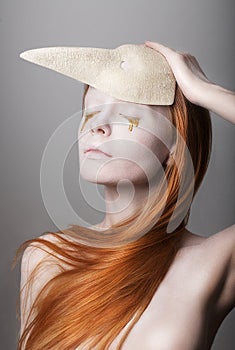 Fanatsy. Stylized Woman with Golden Teardrops holding Carnival Mask photo