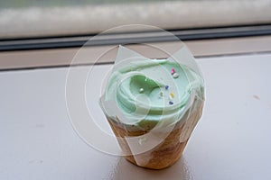 fancy cupcake, green frosting over vanilla cupcake