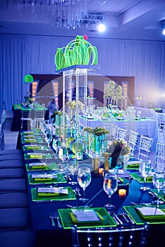 Fancy guest long table set up for a wedding or social event in the ballroom orchid and lucite center piece green photo