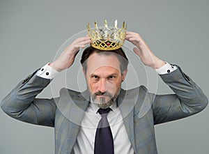 Fancy himself as king. Bearded man wear king crown. Big boss. Leader and leadership. Businessman or business person