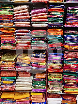 Fancy Indian sarees, Neatly stacked colorful silk saris in racks in a textile shop. Incredible India