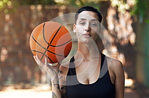 Fancy a little one on one. Cropped portrait of an attractive young female athlete standing on the basketball court.