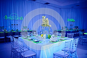 Fancy orchid flower arrangement set up for a wedding party in a ballroom with lucite chairs and decoration photo