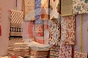 Fancy sarees / unstitched suits hanging and folded on display in a Swadeshi khadi handloom exhibition at Dilli Haat, New Delhi,