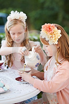 Fancy a spot of tea love. Two young girls having a tea party in the backyard.