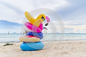 Fancy swim rings on sand beach with blue sea and blue sky background in summer holiday day