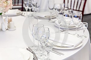 Fancy table set for dinner with napkin glasses in restaurant, luxury interior background. Wedding elegant banquet