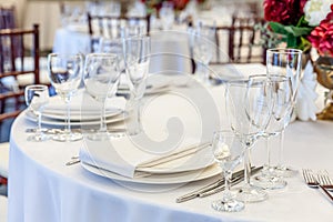 Fancy table set for dinner with napkin glasses in restaurant, luxury interior background. Wedding elegant banquet decoration and