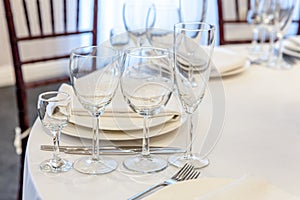 Fancy table set for dinner with napkin glasses in restaurant, luxury interior background. Wedding elegant banquet decoration and