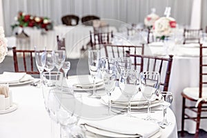 Fancy table set for dinner with napkin glasses in restaurant, luxury interior background. Wedding elegant banquet decoration and