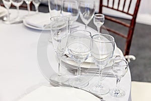 Fancy table set for dinner with napkin glasses in restaurant, luxury interior background. Wedding elegant banquet decoration and