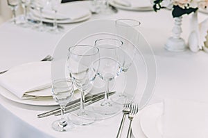 Fancy table set for dinner with napkin glasses in restaurant, luxury interior background. Wedding elegant banquet decoration and