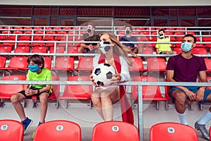 Fans with masks during covid-19 in soccer stadium keeping distance