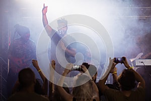 Fans photographing male singer performing at nightclub