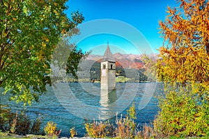 Fantasic autumn view of submerged bell tower in lake Resia