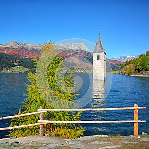 Fantasic autumn view of submerged bell tower in lake Resia