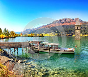 Fantasic autumn view of submerged bell tower in lake Resia