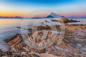 Fantastic azure water with rocks near beach Porto Taverna at sunset photo