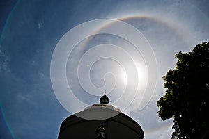 Fantastic beautiful sun halo phenomenon up the church, circular rainbow