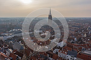 Fantastic Bruges city skyline with red tiled roofs and Church of Our Lady tower in winter day. View to Bruges medieval cityscape