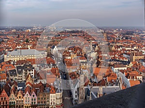 Fantastic Bruges city skyline with red tiled roofs and numerous churches` towers in sunny winter day