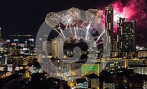 A fantastic and colorful fireworks display over the night sky of the city during a festival