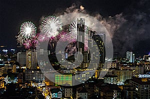 A fantastic and colorful fireworks display over the night sky of the city during a festival