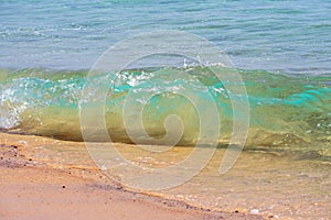 Fantastic colors of transparent water in the ocean. Waves of surf off the coast of Fuerteventura. On the beach.