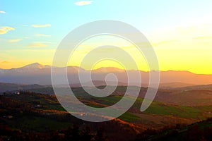 Fantastic landscape with green hills and Sibillini mountains during sunset in Monte Vidon Corrado