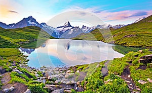 Fantastic landscape at sunrise over the lake in the Swiss Alps, Europe. Wetterhorn, Schreckhorn, Finsteraarhorn et Bachsee.