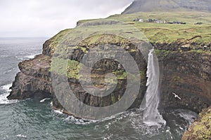 Fantastic landscape with village of Gasadalur and waterfall Mulafossur on the Vagar Island of the Faroe Islands.